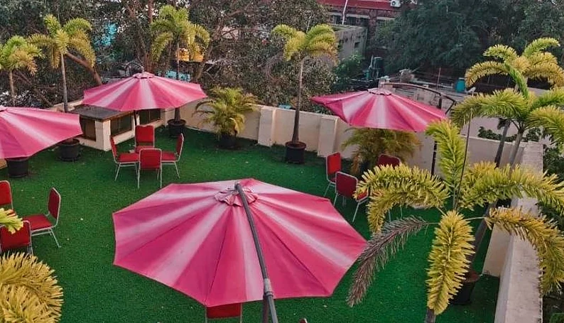 Rooftop lawn terrace with pink parasols and seating